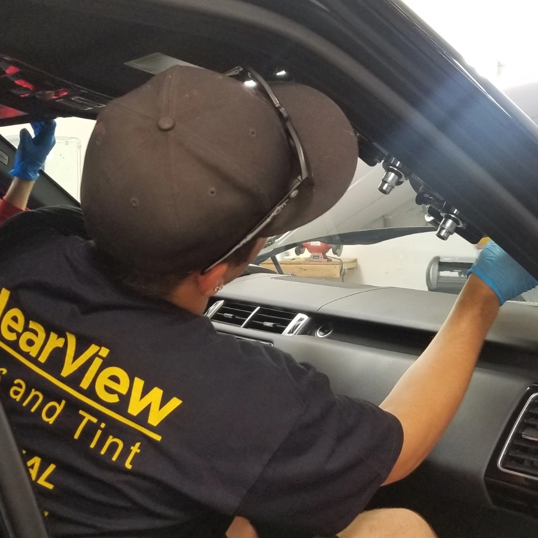 A certified glass technician replacing a windshield