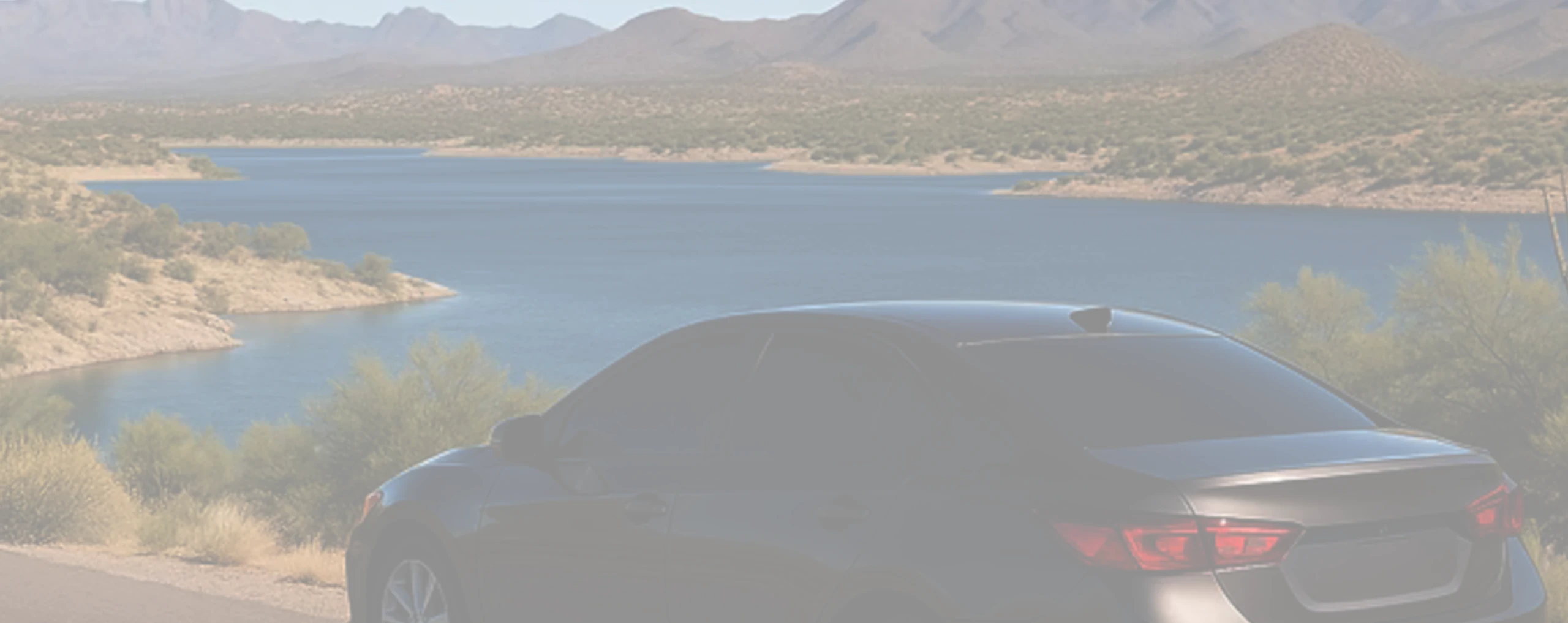 a tinted car parked next to a lake