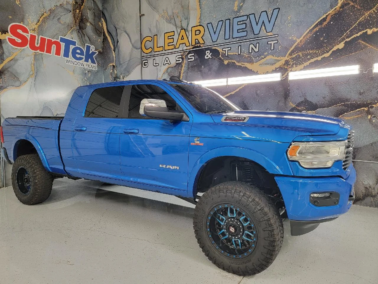 Blue lifted RAM 2500 Cummins truck with tinted windows at Clear View Glass & Tint in Tucson, Arizona, using SunTek window film