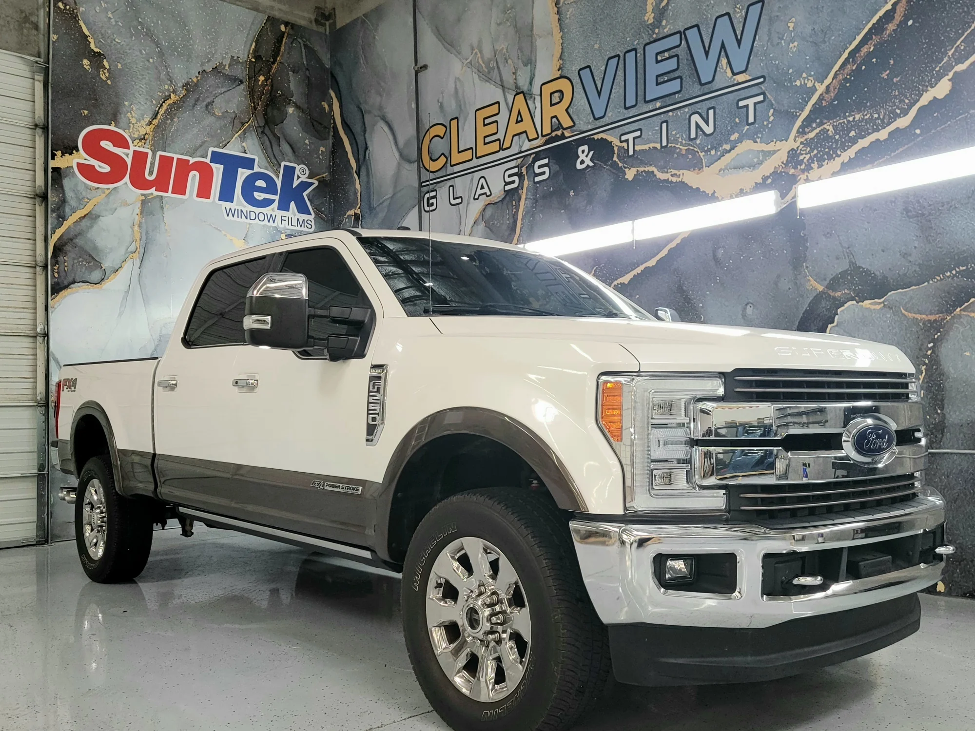 White Ford Super Duty Power Stroke truck with tinted windows at Clear View Glass & Tint in Tucson, Arizona, featuring SunTek window film