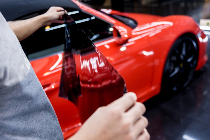 A red vehicle being tinted in Gilbert Arizona
